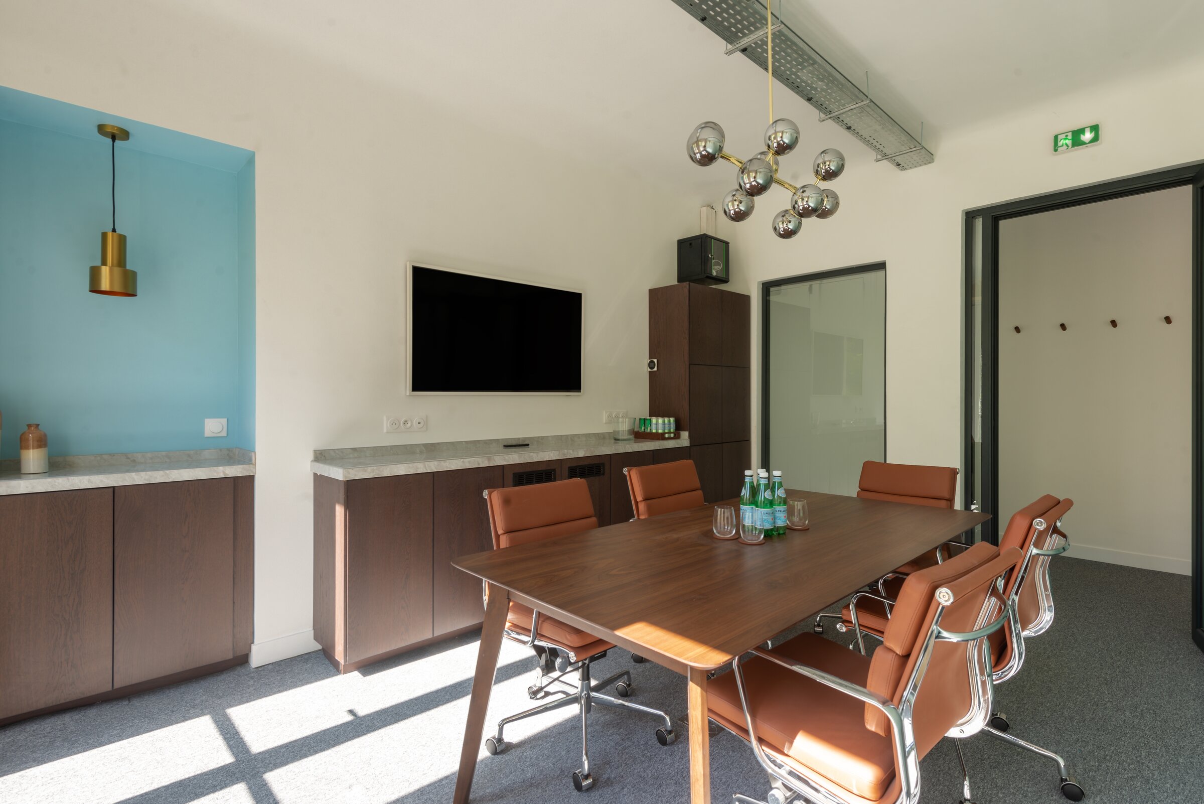 Salle de réunion équipée avec écran et niche bleue